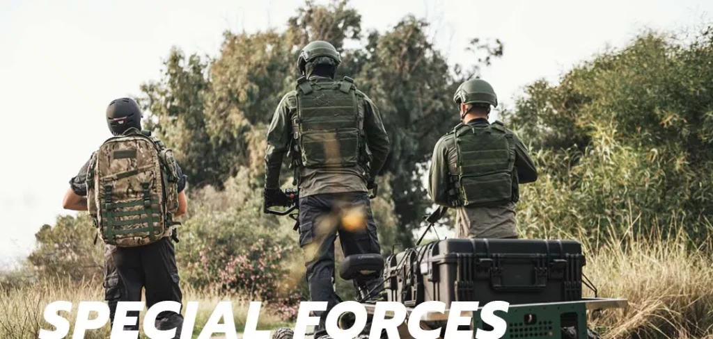 Three special forces soldiers wearing tactical gear and helmets using an EZRaider HD4 4x4 off-road electric scooter during an outdoor mission